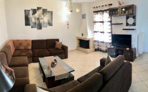 ein Wohnzimmer mit zwei Sofas und einem Fernseher in der Unterkunft Dea House in Finikas
