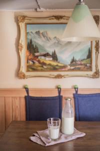 ein Glas Milch auf einem Holztisch mit einem Bild in der Unterkunft Mountain peace in the heart of Switzerland in Emmetten