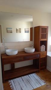 La salle de bains est pourvue de 2 lavabos et d'un grand miroir. dans l'établissement Le Gîte des Murmures, à Urcel