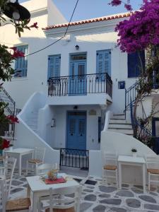 un bâtiment blanc avec des tables et des chaises devant lui dans l'établissement BIANCO BLUE, à Tinos