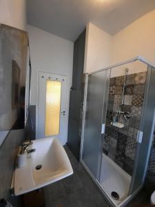 uma casa de banho com um lavatório e um chuveiro em La Casa di Amelie em Parma