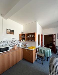 una cucina con armadi in legno e un tavolo in una stanza di 2- izbový APARTMÁN KAJKA v PENZION TRSTENÁ a Trstená