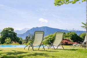 two chairs sitting in the grass next to a pool at Hotel Balm in Luzern