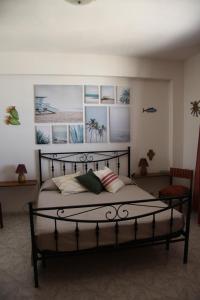 a bedroom with a black bed with pictures on the wall at Casa Clio in Favignana