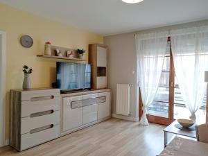 una sala de estar con TV y una cómoda con una bañera de hidromasaje en Bodzafa Apartman en Alsópáhok