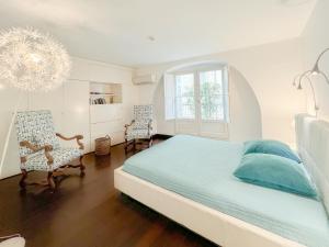 a white bedroom with a bed and two chairs at Appartement 2 chambres avec Terrassse en Hyper centre in Bordeaux