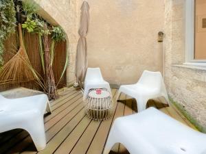 2 chaises et tables blanches sur une terrasse en bois dans l'établissement Appartement 2 chambres avec Terrassse en Hyper centre, à Bordeaux