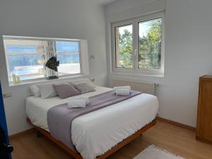 a bedroom with a large bed with two windows at Kizkitza in Gautegiz Arteaga