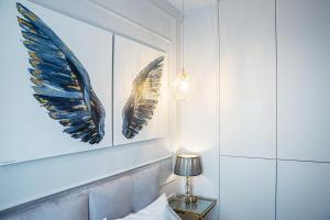 a bedroom with two framed wings on the wall at Top Premium Apartement in Świnoujście