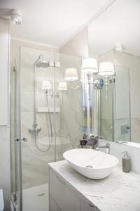 a white bathroom with a sink and a shower at Top Premium Apartement in Świnoujście