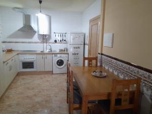 uma cozinha com uma mesa, um lavatório e uma máquina de lavar roupa em Alojamiento Castelar em Sotillo de la Adrada