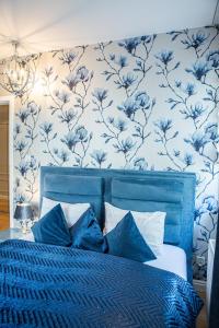a blue bed with blue flowers on a wall at Top Premium Apartement in Świnoujście