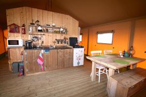 a kitchen with wooden walls and a table in a room at Safaritent Zilverreiger in Lettelbert