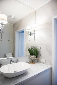 a white bathroom with a sink and a mirror at Top Premium Apartement in Świnoujście