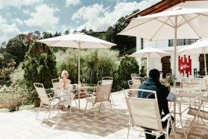 a couple sitting at a table with umbrellas at Jordan Hotel Boutique in Guatapé +65 photos