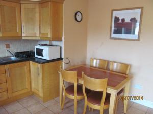 cocina con mesa con sillas y microondas en Holiday Home Tralee Ireland, en Tralee