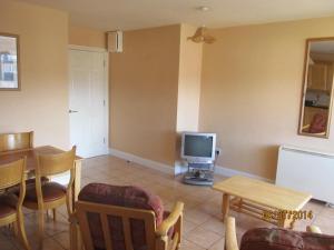 ein Wohnzimmer mit einem TV und einem Tisch in der Unterkunft Holiday Home Tralee Ireland in Tralee