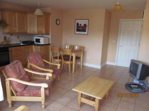 een keuken met een tafel en stoelen en een televisie bij Holiday Home Tralee Ireland in Tralee +10 foto's