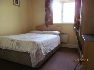 a small bedroom with a bed and a window at Holiday Home Tralee Ireland in Tralee