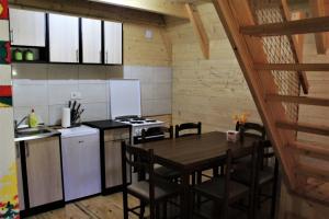 a kitchen with a table and a stove top oven at Log - cabin HOPE in Žabljak