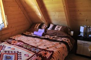 a bedroom with a bed in a log cabin at Log - cabin HOPE in Žabljak