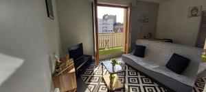 a living room with a couch and a large window at "La Dolce Vita" Studio cosy avec balcon in Pau