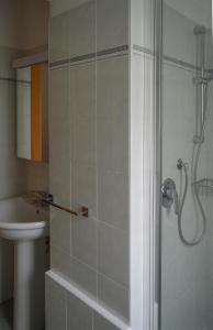 uma casa de banho com um chuveiro e um lavatório. em Da Sid em Tremezzo