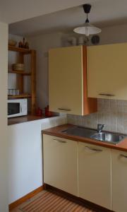 a kitchen with yellow cabinets and a sink at Da Sid in Tremezzo