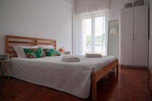 una camera da letto con un grande letto con asciugamani di Ana's Guesthouse a Sintra