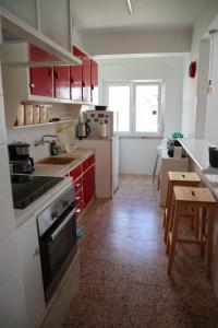 a kitchen with red cabinets and a table in it at Ana's Guesthouse in Sintra