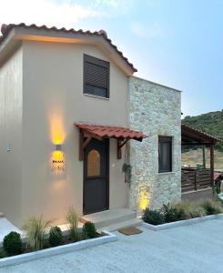 Casa pequeña con un edificio de piedra con porche en Palma Seaside Villa 1, en Sarti