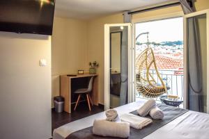 a bedroom with a bed and a balcony with a chair at Entelia in Skiathos Town