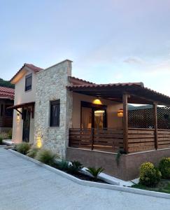 een huis met een veranda en een houten terras bij Palma Seaside Villa 2 in Sarti