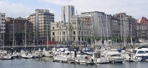 een groep boten aangemeerd in een jachthaven in een stad bij Hostal Verdemar in Gijón