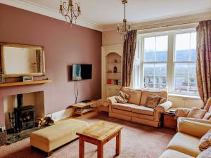 uma sala de estar com um sofá e uma lareira em Huge 4 Bed Apt - Perfect Base to Explore The Borders em Jedburgh