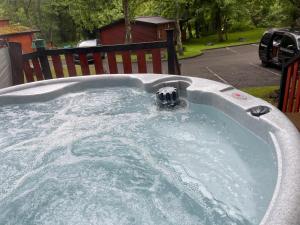 a jacuzzi tub with a fountain in a yard at L02 - The Penrhyn Spa with Hot Tub in Bethesda