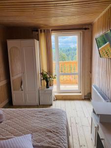 a bedroom with a bed and a large window at Villa Maria in Yablunytsya