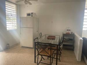 a kitchen with a table and a white refrigerator at Large 5 Bedrooms Home in Bayamon Puerto Rico in Bayamon