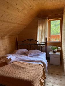 a bedroom with two beds in a wooden house at Villa Maria in Yablunytsya