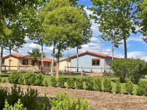 una casa en el fondo con árboles en el primer plano en Natura Resorts en Casalarreina
