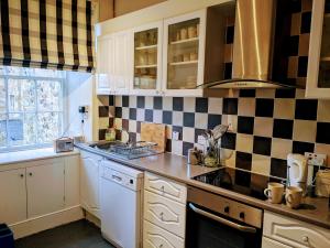 a kitchen with black and white tiles on the wall at Huge 4 Bed Apt - Perfect Base to Explore The Borders in Jedburgh