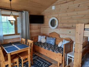 Dormitorio en cabaña de madera con cama y mesa en Tohninmäen Talo, en Töysä