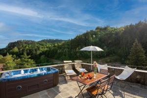 a patio with a hot tub and a table and chairs at Medieval Tower Lungarno your wedding in Tuscany in Pratovecchio