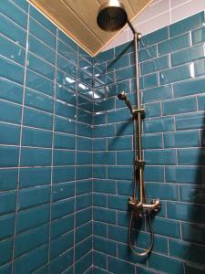 a blue tiled bathroom with a shower at Cosy Apartments in Vilnius Center in Vilnius