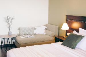 Habitación con cama, sofá y mesa. en Althaia Hotel, en Thermo
