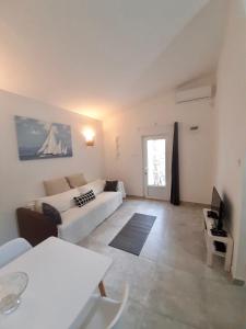 a living room with a white couch and a table at Apartment White in Petrovac na Moru