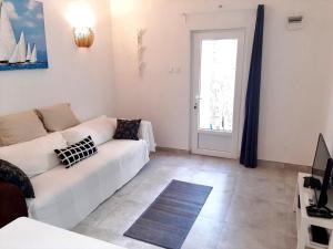 a living room with a white couch and a window at Apartment White in Petrovac na Moru +25 photos