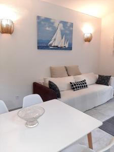 a living room with a white couch and a white table at Apartment White in Petrovac na Moru
