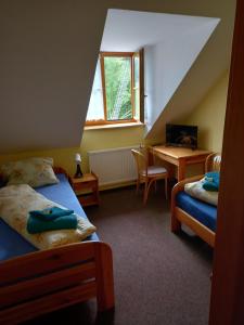 1 Schlafzimmer mit 2 Betten, einem Tisch und einem Schreibtisch in der Unterkunft Hotel Nové Údolí in Stožec