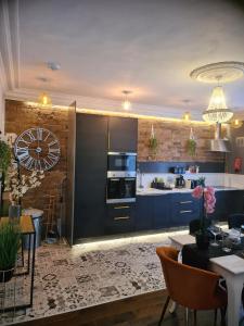 a kitchen with blue cabinets and a dining room at Albert Rd Aparthotel in Colne